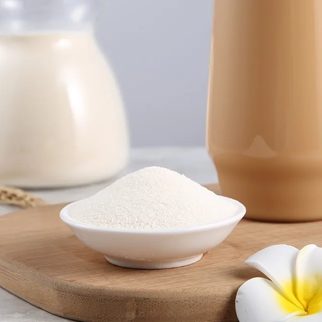 Close-up of non-dairy creamer powder in a bowl, with milk and milk tea behind it — Cha Xiaoleng